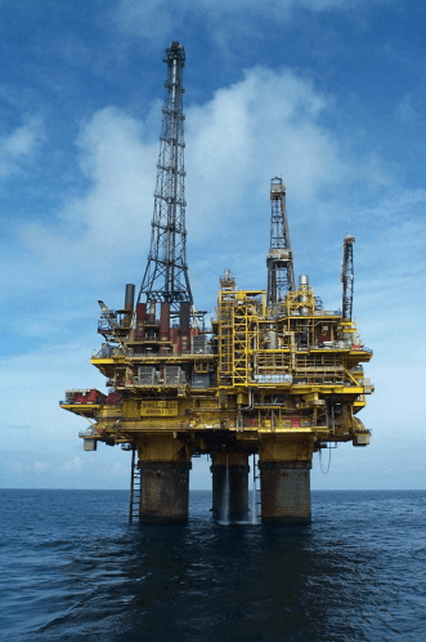 Offshore oil rig under a cloudy sky.