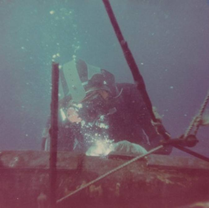 Underwater diver performing welding work.