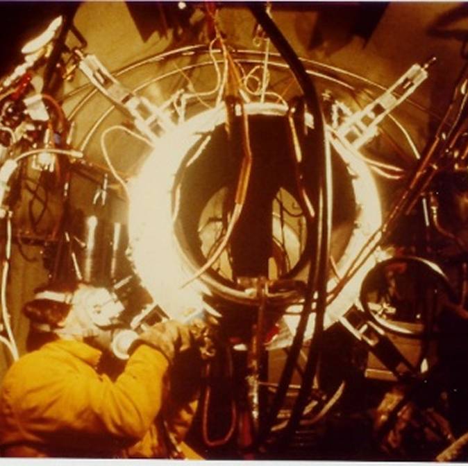 Technician working on complex machinery and wires.