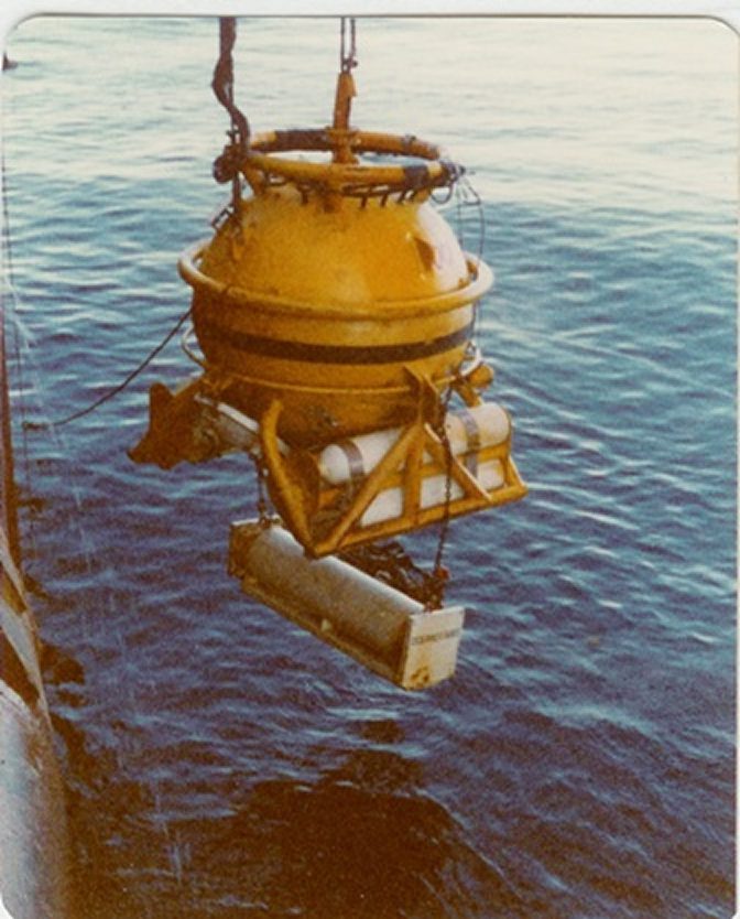 Yellow buoy being lowered into the ocean.