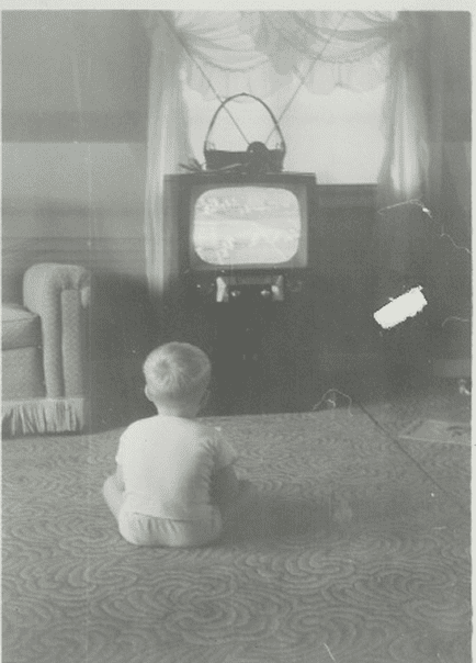 Child watching vintage television in living room.