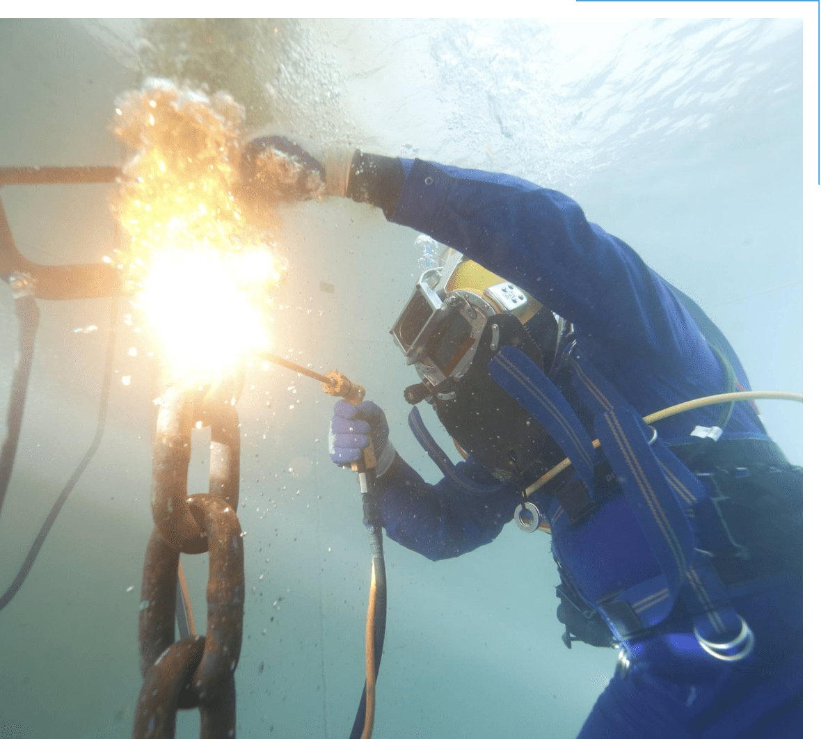 Underwater welder working on metal chain.