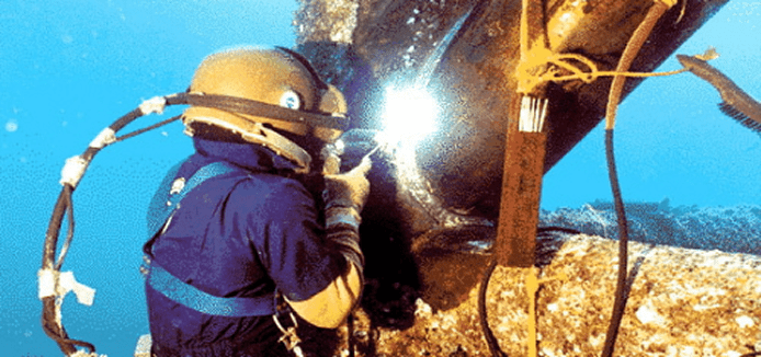 Underwater diver welding metal structure.