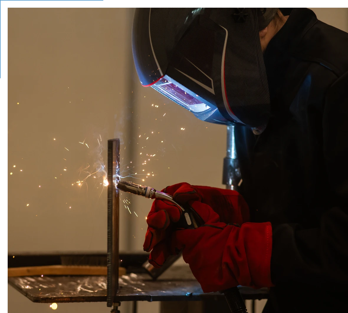 Person welding metal with protective gear.