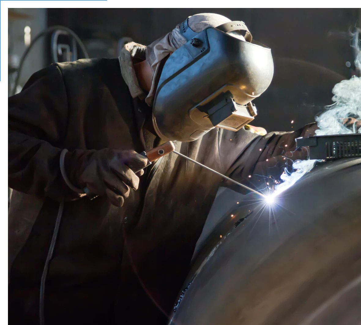 Welder working on large metal structure.